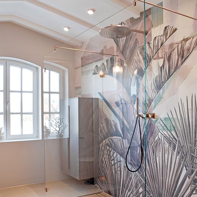 Dusche mit Glaswänden und dekorativer Feuchtraumtapete