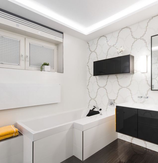 Raumsparende Badewanne mit Wandfliesen Mosaik in schwarz-weiß Design