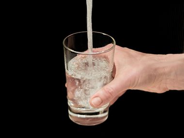 ein Glas wird mit Trinkwasser gefüllt
