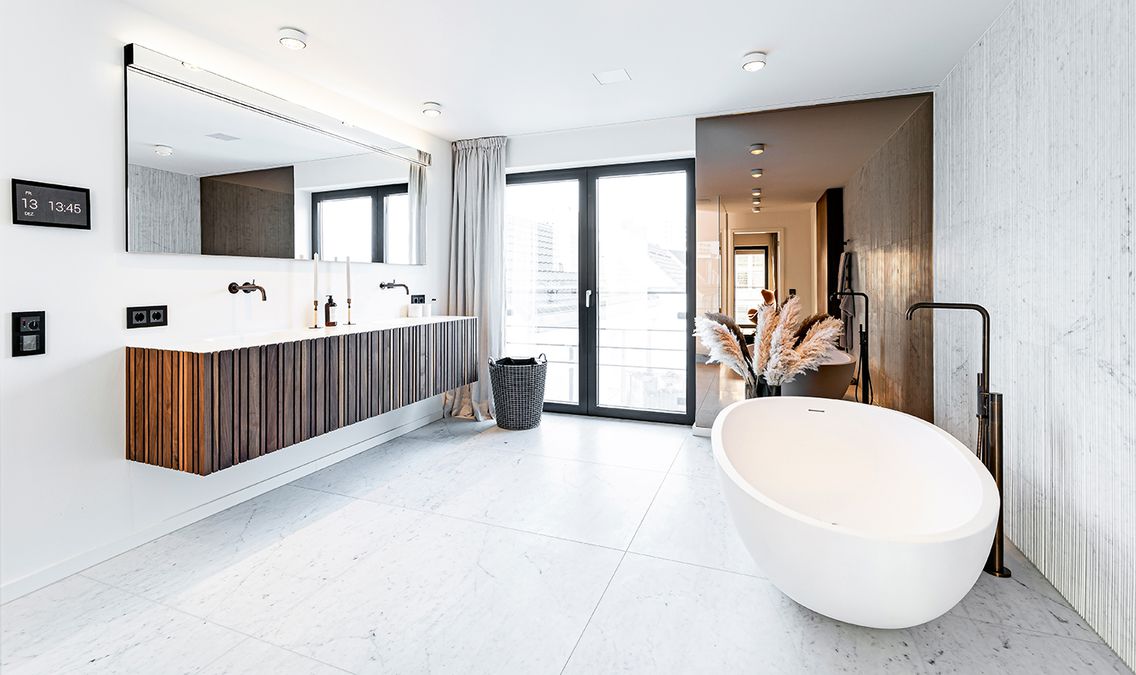 helles, modernes Tageslichtbad mit freistehender Badewanne und Spiegel