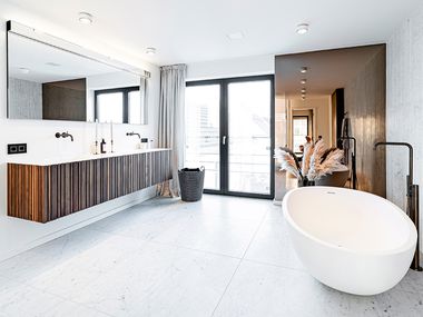 helles, modernes Tageslichtbad mit freistehender Badewanne und Spiegel